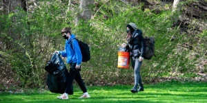 ein schüler und eine Lehrerin sammeln im Park Müll